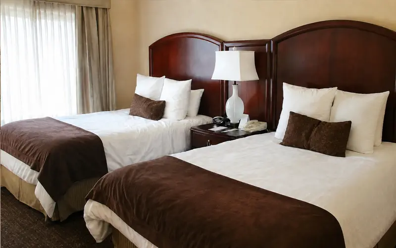 wo beds with dark wood headboards and brown-and-white bedding inside our Caribe Royale Orlando suite.
