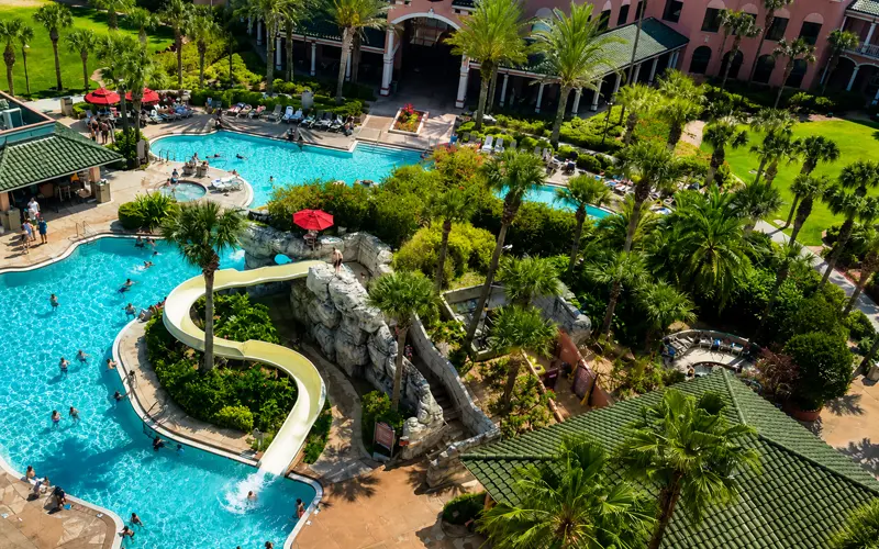 Aerial view of the Caribe Royale Orlando pool, waterslide, and tropical landscaping.