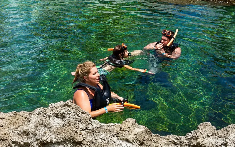 Family snorkeling together in Turtle Lagoon at Cayman Turtle Centre in Grand Cayman.