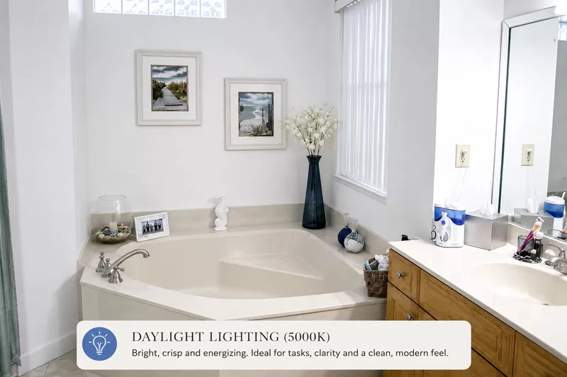 Bathroom illuminated with daylight light bulbs showing bright cool-toned lighting around a soaking tub and vanity