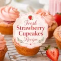 Fresh strawberry cupcakes with pink frosting and baked strawberry slices on a cooling rack