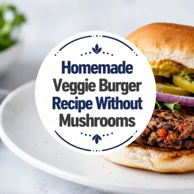 Hand-shaped black bean burger with lettuce, pickles, red onion, and mustard on a white plate.