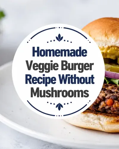 Hand-shaped black bean burger with lettuce, pickles, red onion, and mustard on a white plate.