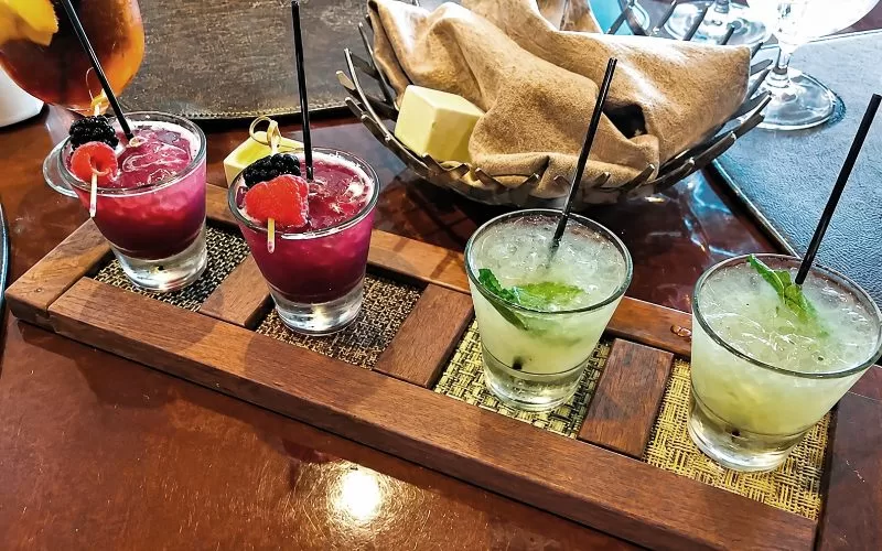 Colorful drinks served on a wooden tray at Champions Bar & Grill at Trump National Doral Miami.