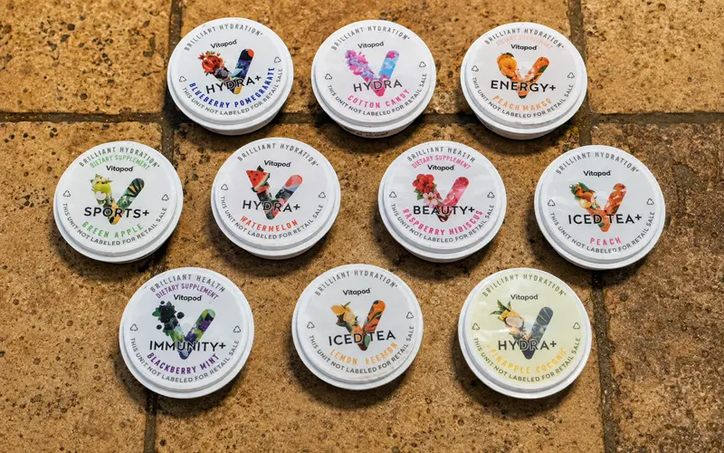 Ten Vitapod flavor pods arranged on a stone countertop