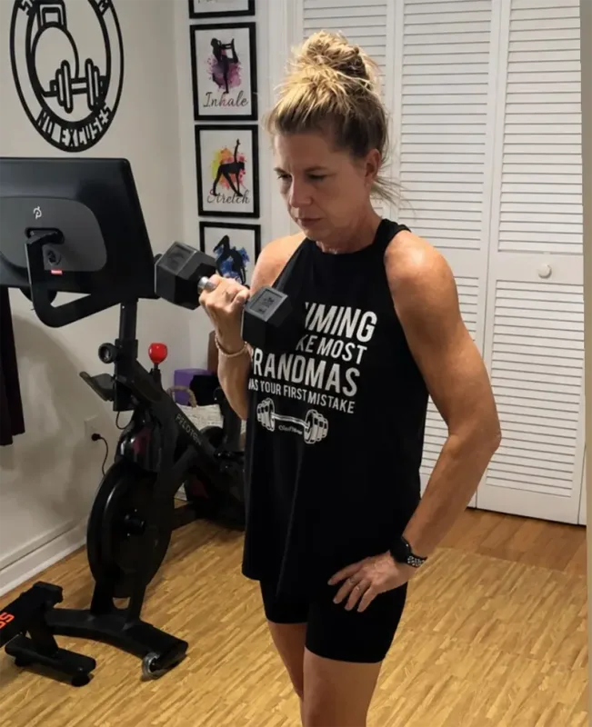 Wearing a black ClubFitwear rocker tank during a home strength workout