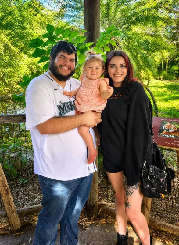Couple posing with a young child during a visit to the Palm Beach Zoo.