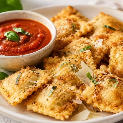 Golden breaded ravioli served with marinara dipping sauce, Parmesan shavings, and fresh basil.