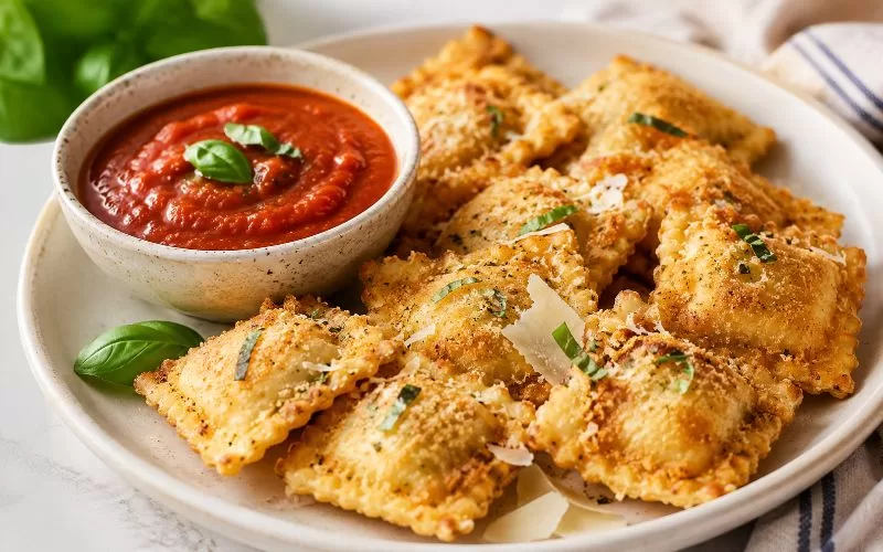 Golden breaded ravioli served with marinara dipping sauce, Parmesan shavings, and fresh basil.