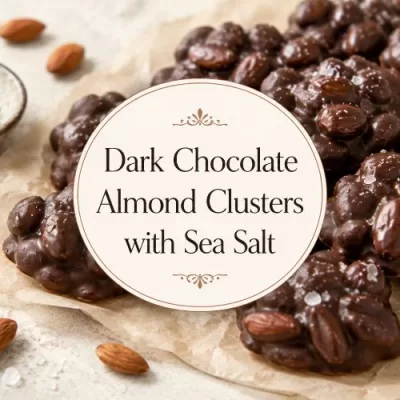 Dark chocolate almond clusters with flaky sea salt, whole almonds, and a centered title overlay on a warm food background.