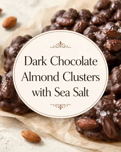 Dark chocolate almond clusters with flaky sea salt, whole almonds, and a centered title overlay on a warm food background.