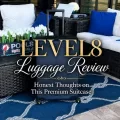 Navy LEVEL8 suitcase on a blue patio rug with decorative text that reads LEVEL8 Luggage Review Honest Thoughts on This Premium Suitcase.