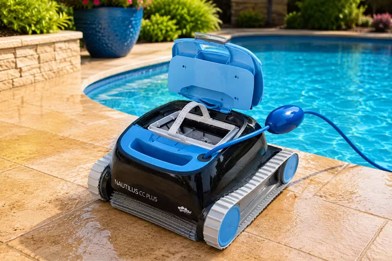 Open top-loading filter basket inside the Dolphin Nautilus CC robotic pool cleaner displayed beside a backyard swimming pool.