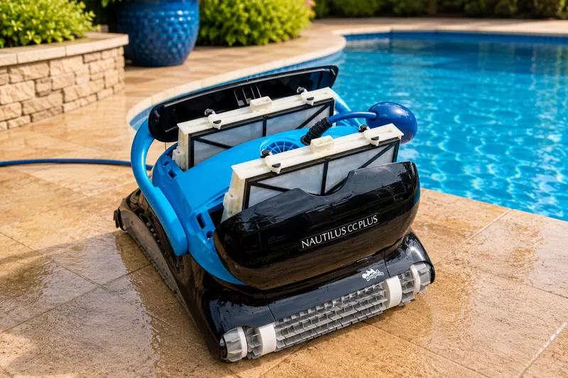 Dolphin Nautilus CC Plus robotic pool cleaner with both filter basket compartments open beside a backyard swimming pool.