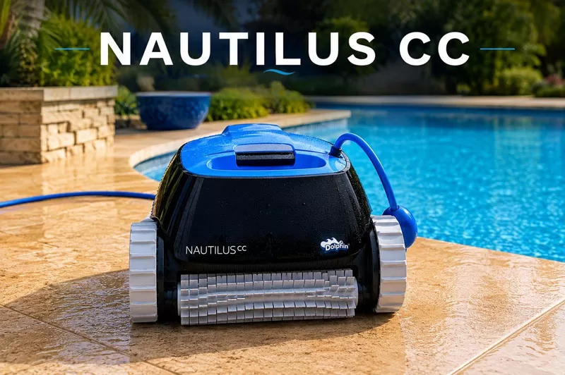 Dolphin Nautilus CC robotic pool cleaner sitting beside a backyard swimming pool with palm trees and tropical landscaping in the background.