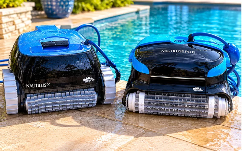 Dolphin Nautilus CC and Nautilus CC Plus robotic pool cleaners sitting poolside next to a backyard swimming pool for side-by-side comparison review.