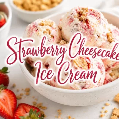 Bowl of strawberry cheesecake ice cream with fresh strawberries, graham cracker pieces, and decorative text that reads Strawberry Cheesecake Ice Cream.