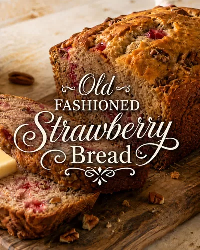 Old fashioned strawberry bread with decorative title text over sliced homemade bread and strawberries.