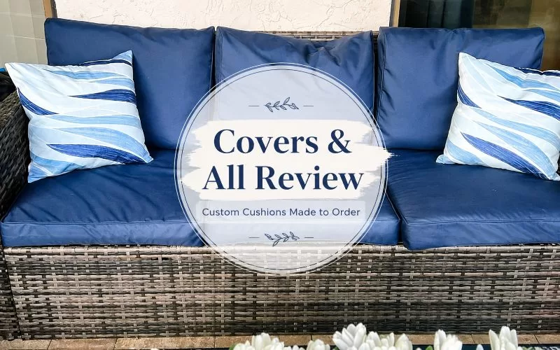 Navy outdoor patio couch cushions with striped pillows and a centered Covers & All Review overlay.