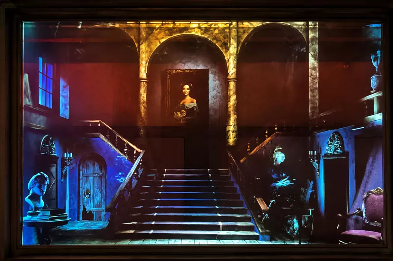 Halloween window projection showing a haunted mansion scene with stairs and ghostly figures