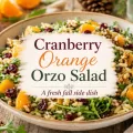 Cranberry orange orzo salad with dried cranberries, orange segments, walnuts, and arugula with a centered recipe title graphic