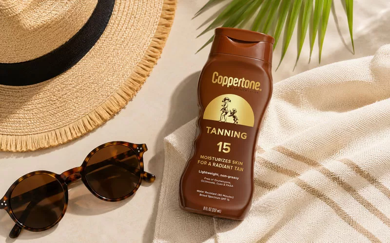 Coppertone sunscreen with sunglasses and a straw sun hat in a sunny summer setting