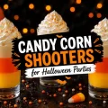 Halloween candy corn shooters with layered orange, yellow, and cream-colored shots topped with whipped cream and festive sprinkles in a spooky party setting.