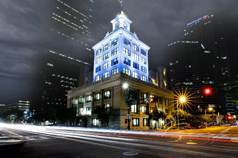 Historic Old City Hall building in downtown Tampa illuminated at night with glowing city lights and long exposure traffic trails.