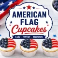 Patriotic American flag cupcakes decorated with blueberries and red white striped frosting on a festive dessert tray