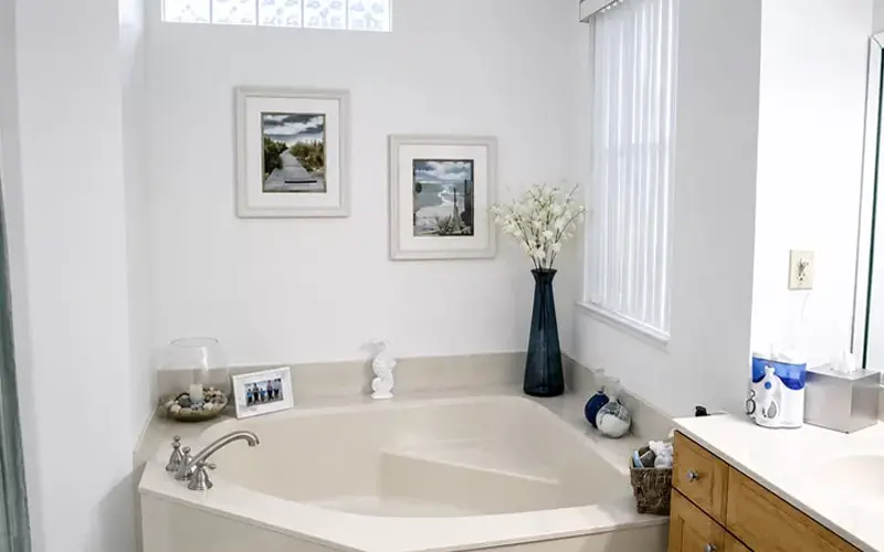 Bathroom illuminated with daylight light bulbs showing bright cool-toned lighting around a soaking tub and vanity