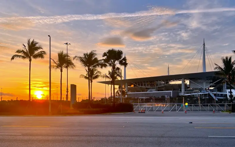 Hard Rock Stadium in Miami Gardens surrounded by palm trees at sunset
