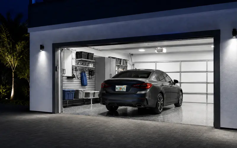 Modern car parked securely inside a residential garage at night.