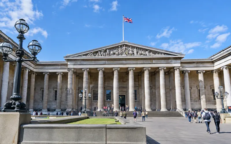 Grand entrance of a London museum beneath a bright daytime sky