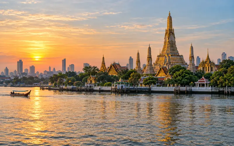 Golden Bangkok temple beside the Chao Phraya River at sunrise